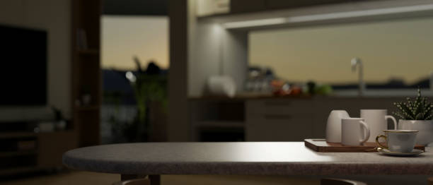 istock Copy space on a dining table with a mug tray and a potted plant in a modern kitchen in the evening. 1699584945