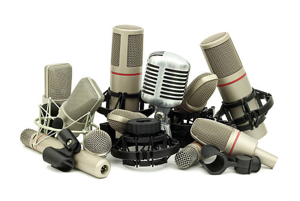 Microphone with pop filter and headphones hanging up in the background.