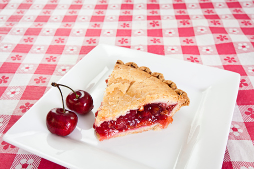 Slice of cherry pie on picnic table