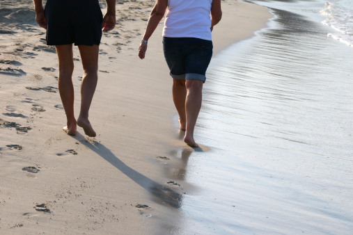 mature couple walking on the beach in early morning