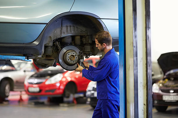 Hard-working and experienced A mechanic cleaning a cars wheel bearing with a cloth car mechanic top view stock pictures, royalty-free photos & images