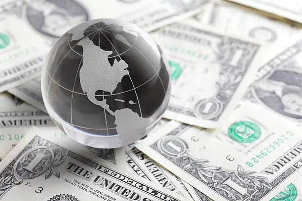 Photo of glass globe and money