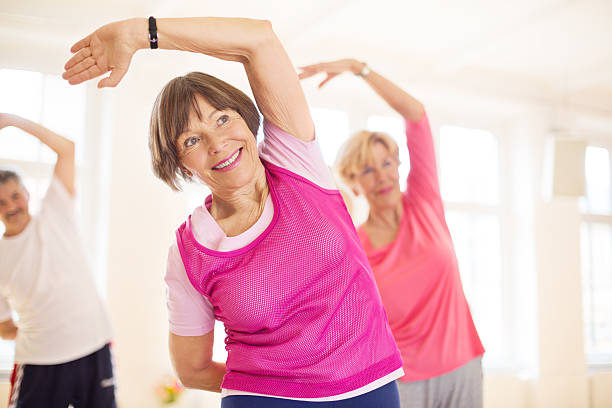 Group of senios in the yoga studio Group of happy seniors practising yoga  aerobics stock pictures, royalty-free photos & images