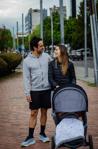 istock couple smiling with stroller walking in the street 1699625137