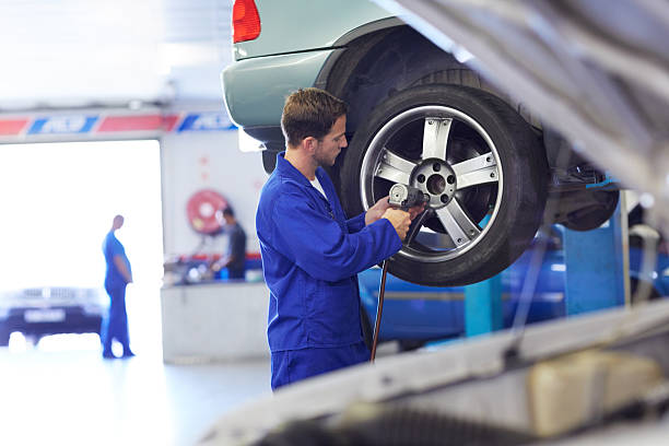 One of the hardest workers A mechanic torquing the lug nuts of a wheel with a drill car mechanic top view stock pictures, royalty-free photos & images