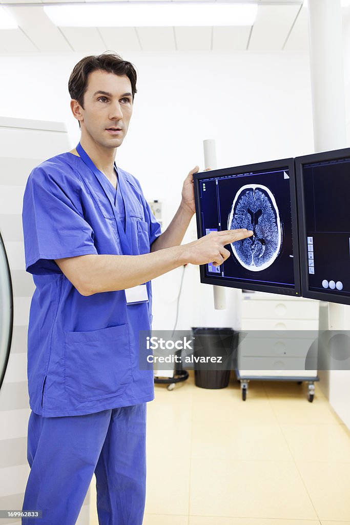 Hospital técnico explicando una tomografía cerebral - Foto de stock de Maquinaria libre de derechos