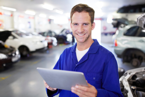 Portrait of a diligent mechanic using a digital tablet in his auto repair shop