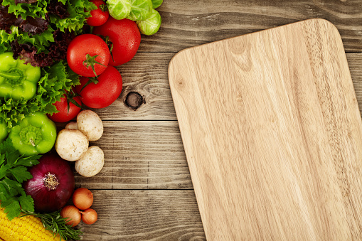 Directly above view of cutting board with raw vegetables around it