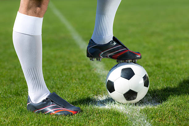 football player waiting for kick-off close up close up legs of soccer player with football waiting for kick-off at centre sport on playing field football socks stock pictures, royalty-free photos & images
