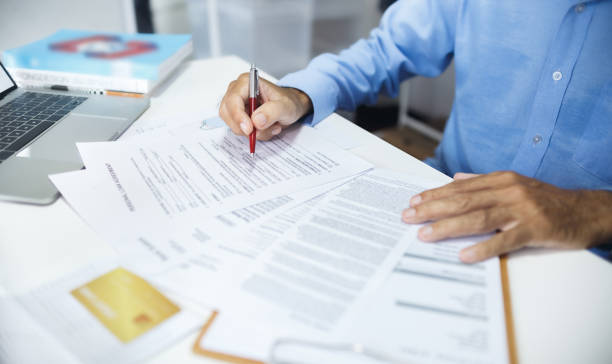 businessman working on desk Accountant working on desk with laptop checking business document and loan, bank statement and calculate interest and taxes before finalizing the account invoice pad stock pictures, royalty-free photos & images