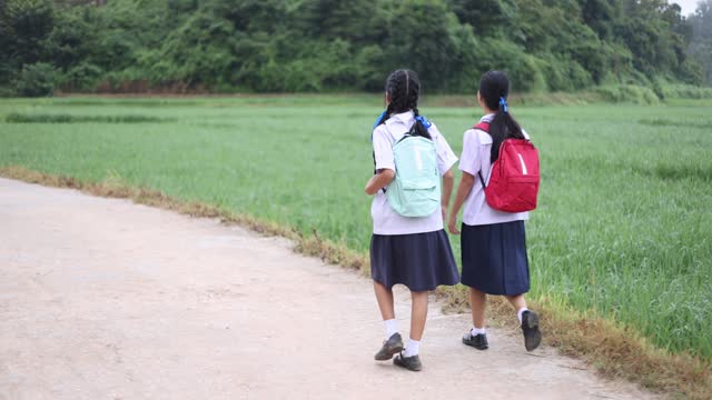 Young girl high school students in rural Thailand are walking to school in the morning.