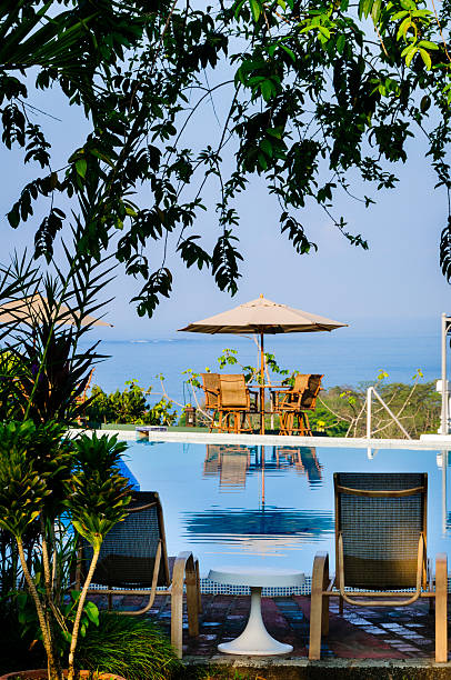 istock Lounge chairs and umbrellas poolside at a tropical resort 169969185