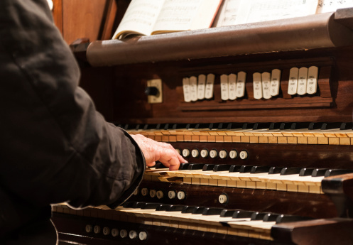 Old man playing an old organ