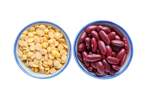 Yellow split peas in a bowl, red kidney seeds in a bowl on white background with clipping path.Top view