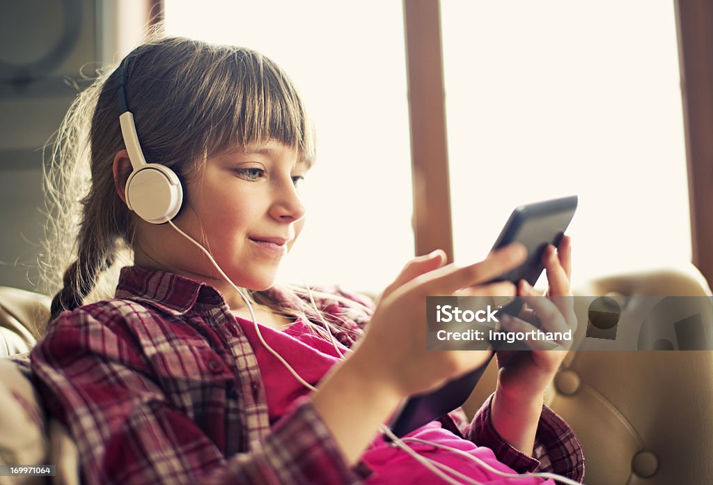 Niña y un comprimido - Foto de stock de Auriculares - Equipo de música libre de derechos