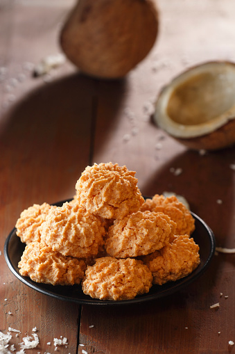 Close-up of a delectable batch of coconut macaroons beautifully arranged on a rustic wooden surface.