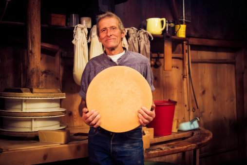 traditional cheesemaking - farmer holding wheel of cheese