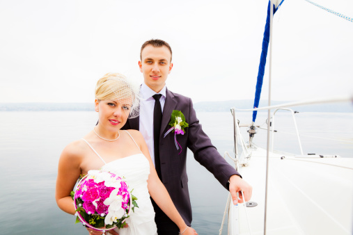 a happy pair of newlyweds with their yacht