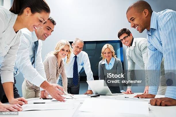 People Standing Around A Table With A Laptop Stock Photo - Download Image Now - Community, Finance, A Helping Hand