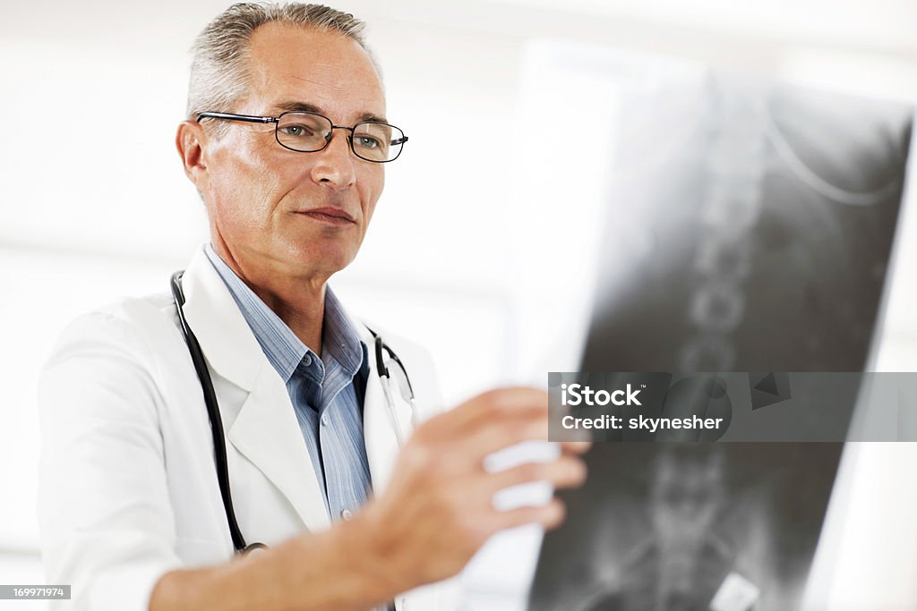 Retrato de médico examinar radiografías de columna. - Foto de stock de Doctor libre de derechos