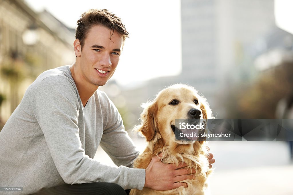 Lächelnd teenager und seinen Hund gut behandelt. - Lizenzfrei Männer Stock-Foto