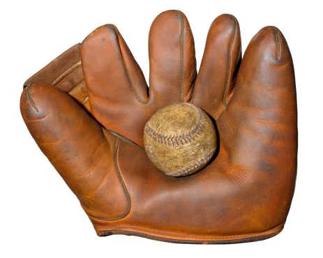 An antique baseball glove with an authentic 1920's baseball isolated on a white background with a clipping path.