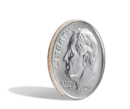 A US dime, ten cents, isolated on a white background with a shadow. There is a clipping path which may be used to delete the shadow if desired.