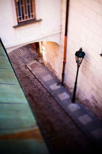 An old European-style narrow alleyway with a lamp and cobblestones from above in Prague, Czech Republic
