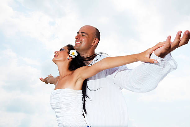 bela casado casal contra o céu. - bride wedding freedom arms raised imagens e fotografias de stock