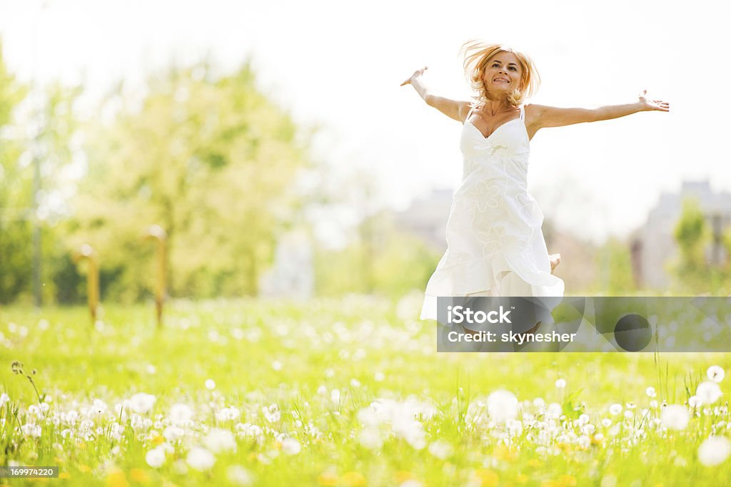 Hermosa joven rubia en el parque salto - Foto de stock de Actividad libre de derechos