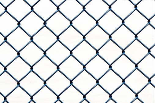 Closeup black wire fence against white background, full frame horizontal composition with copy space