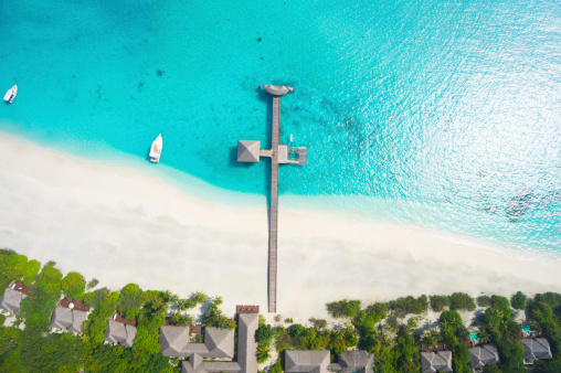 aerial view tropical island with wide sandy beach jetty and lagoon