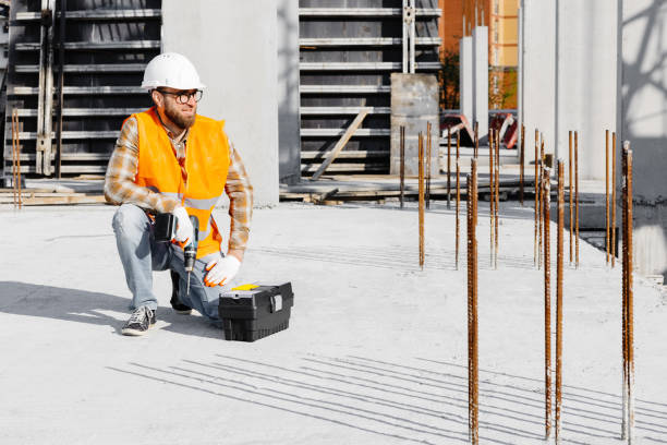 istock Repairman worker in uniform and helmet working with cordless screwdriver and tool box 1699778348