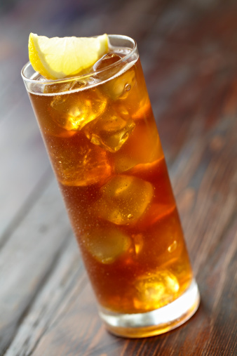 Iced tea with wedge of lemon and water droplets on glass shot with shallow focus.  Professionally shot, color corrected, silhouetted and retouched in 16bit,  for maximum image quality.