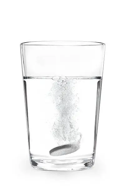 A antacid tablet in a glass of water.