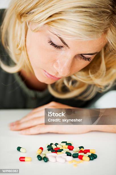 Hermosa Mujer Rubia Está Estudiando La Pila De Pastillas Foto de stock y más banco de imágenes de Adulto