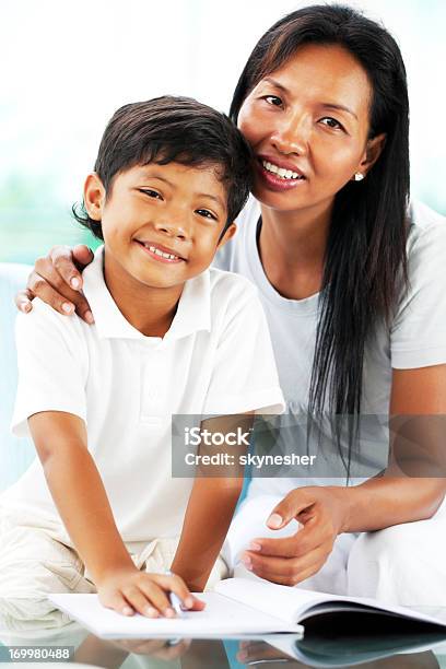 Asiatiche Madre Aiutando Suo Figlio Con I Suoi Compiti A Casa - Fotografie stock e altre immagini di 30-34 anni