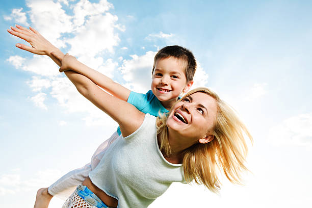 istock Beautiful mother giving her son a piggyback ride. 169980806