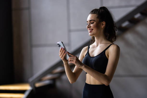 istock Fit woman uses a smartphone at home before training at home 1699821028