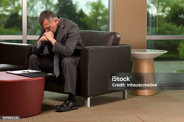 Foto de Empresário Sentando Inclinandose Para Frente Com As Mãos Na Cabeça e mais fotos de stock de 50 Anos