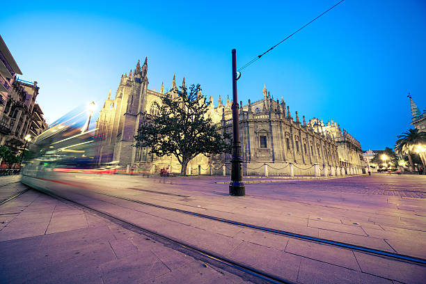Entrance door of La Giralda in Seville and a tram passing on.