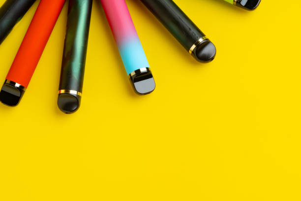 istock Colorful disposable electronic cigarettes on yellow background 1699846617