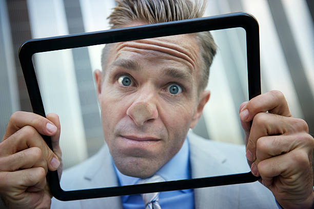 istock Businessman Presses His Nose Against Tablet Computer 169984859