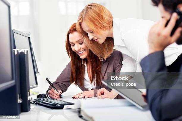 Coworkers In The Office Communicate And Reviewing Documentation Stock Photo - Download Image Now