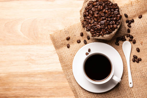 istock Flat lay, top view Black coffee in coffee cup with coffee beanand on wooden table 1699865832