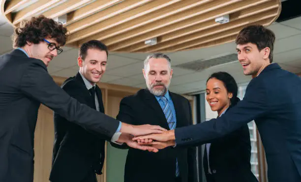 Photo of Executives in Formal Attire Mark a Momentous Business Partnership with a Handshake. Professional Colleagues Seal a Lucrative Business Deal with a Handshake and Contract Signing.