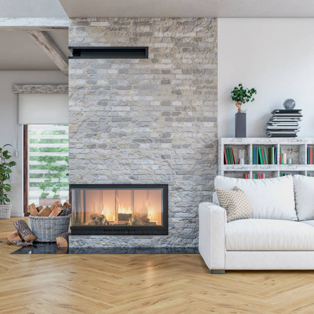 istock Cozy, luxurious, and modern  living room with white sofa, lit fireplace, windows, with decoration 1699878322
