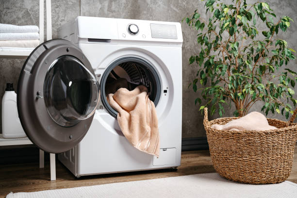 istock Laundry room interior with washing machine near gray grunge wall 1699883278