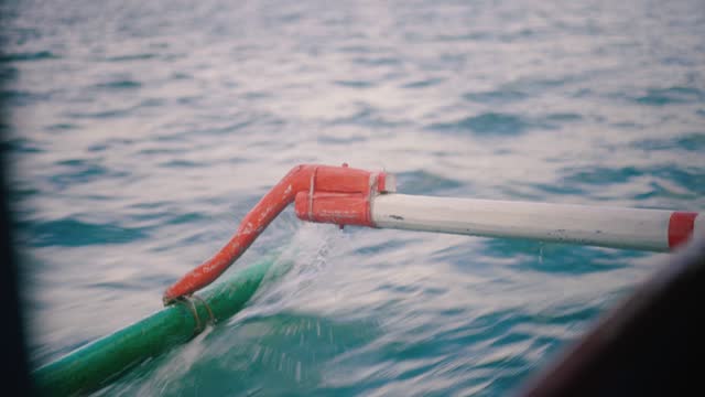 Close Ups of Wooden Boat with Outrigger At Sea