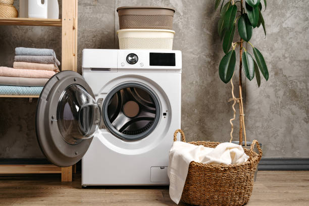 istock Laundry room interior with washing machine near gray grunge wall 1699887688